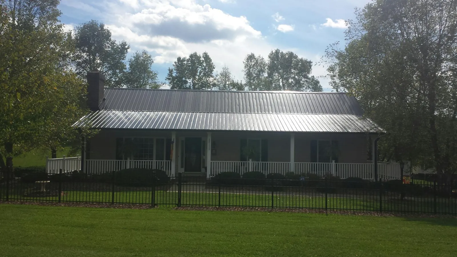 Gray metal roof on a brick ranch with a full width front porch — Gutter Guard Installation work by our crew in Brunswick