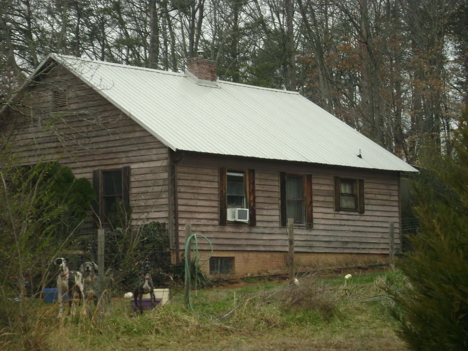 White metal roof on an old wood sided farmhouse, from a Metal Roof Installation job in Brunswick